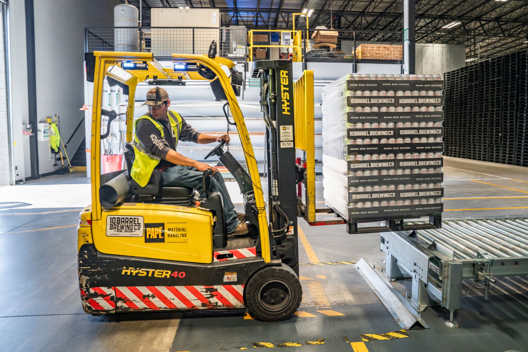 Forklift operator moving cargo inside a warehouse