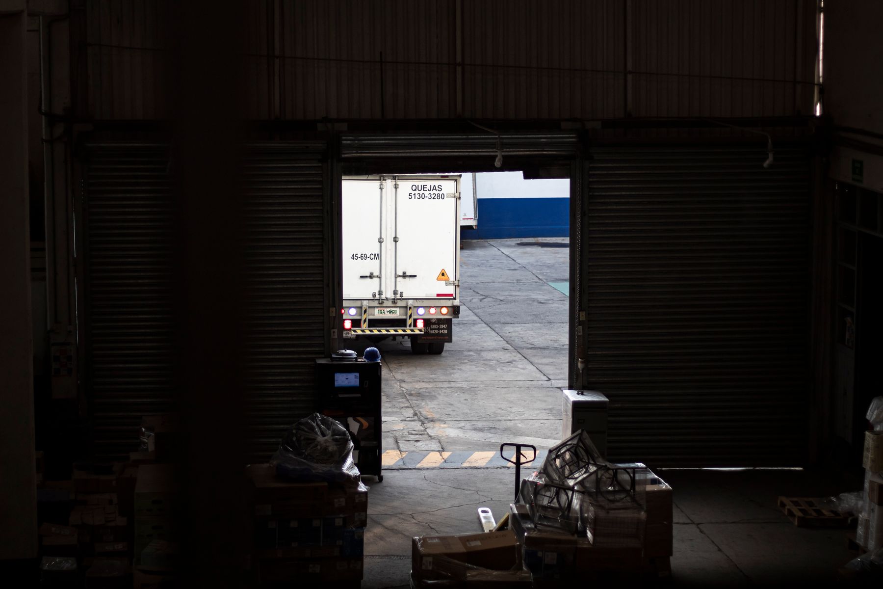 White cargo truck positioned at a warehouse loading dock