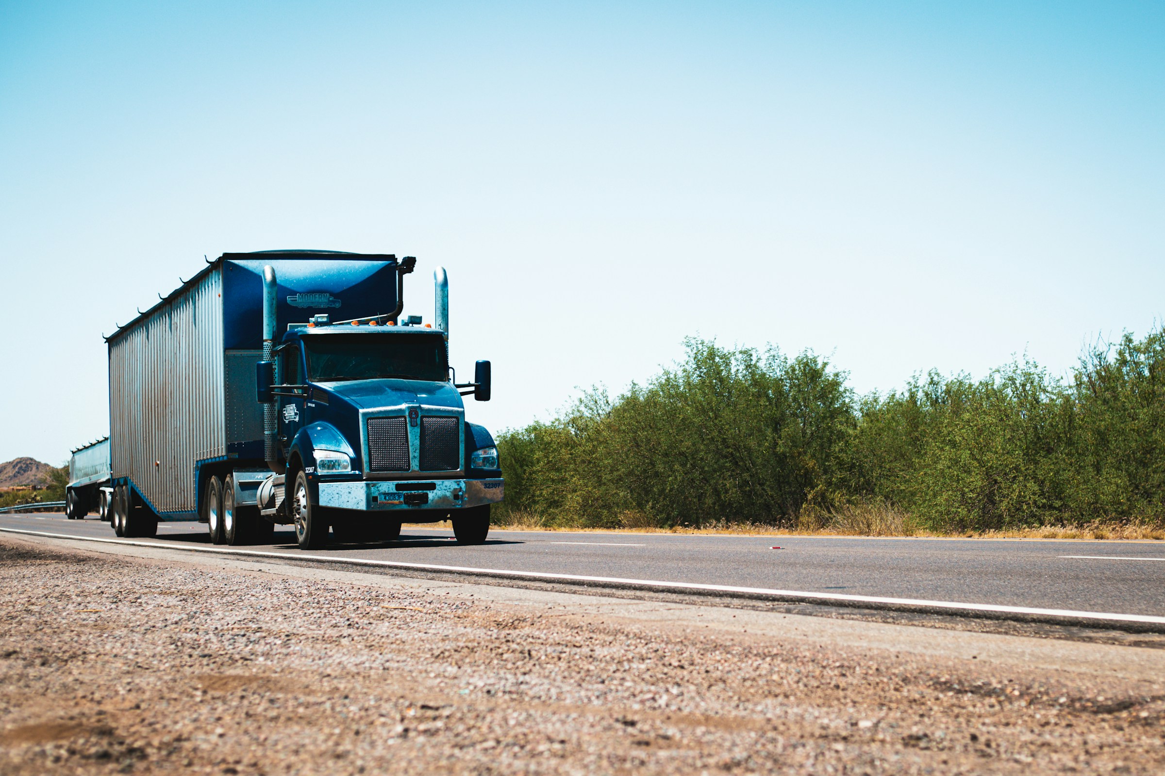 Semi-truck traveling through a desert landscape
